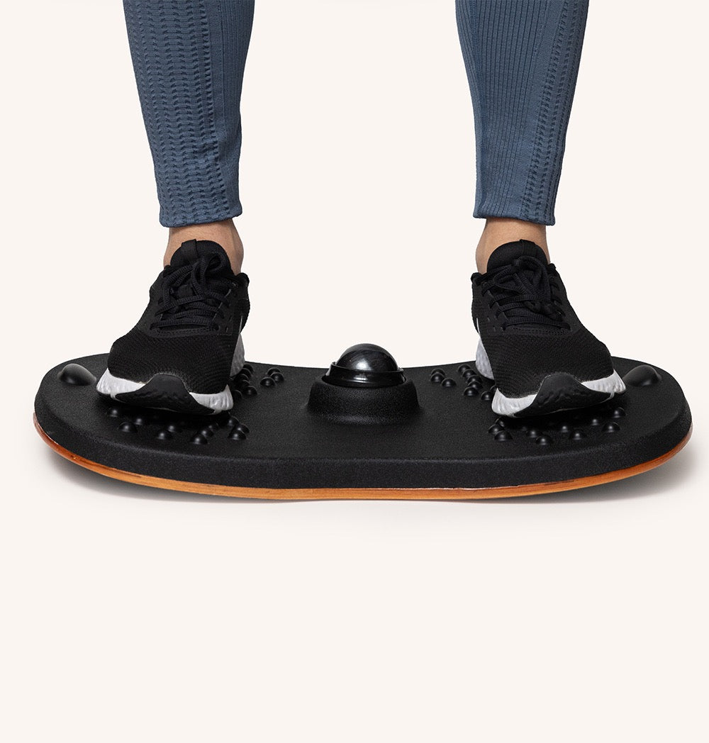 Person standing on a Standy Balance Board to improve balance and posture during work.