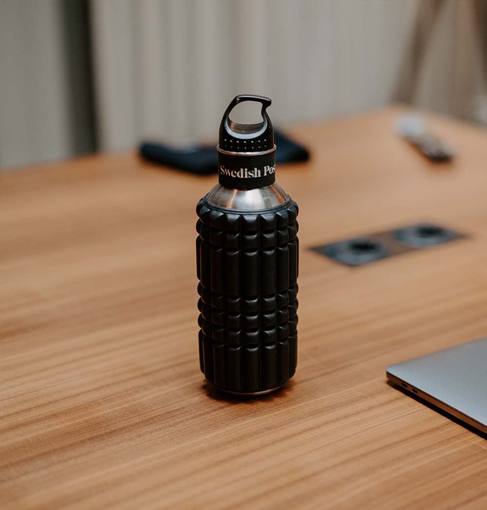 Stylowa butelka na wodę 2w1 z wbudowanym wałkiem do masażu na biurku.